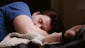 woman in blue shirt lying on bed