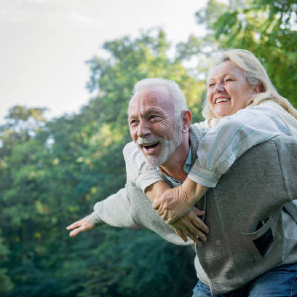 Happy senior couple smiling outdoors in nature